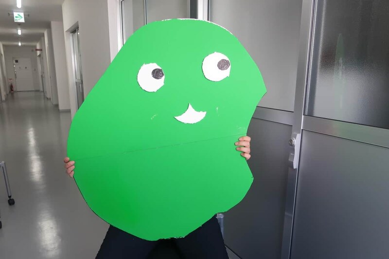 「ナウルくん」のパネルを持ってJ-CASTニュースの取材に応じるナウル政府観光局Xの「中の人」。万博への取り組みについて語った