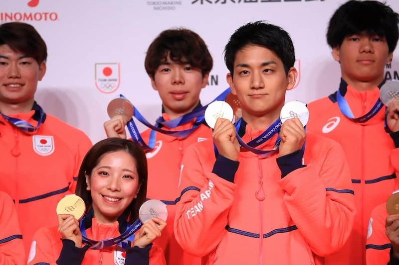 記者会見でメダルを手に笑顔を見せる「りくりゅう」こと三浦璃来選手(左)と木原龍一選手(右)