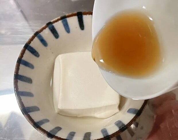 豆腐にタレをかける（撮影：grape編集部）