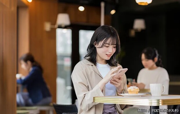 カフェで写真を撮る女性の写真