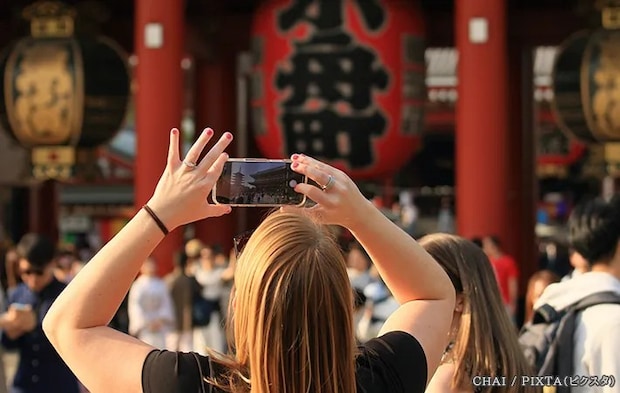 観光地で写真を撮る女性の写真