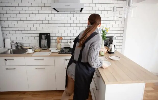 キッチンで作業をしているエプロン姿の女性