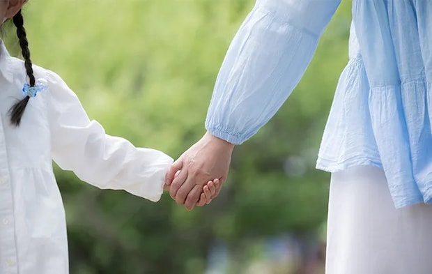 手をつなぐ親子の写真