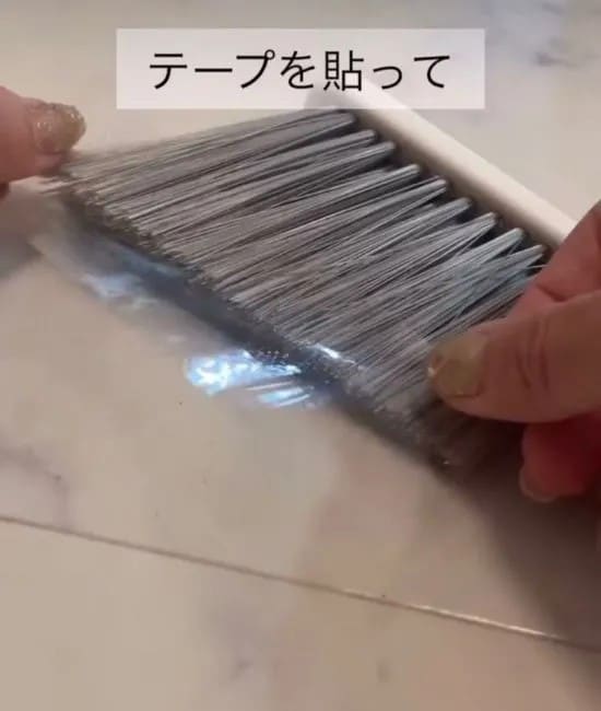 ほうきにテープを貼る様子