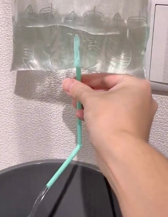 水を入れたフリーザーバッグに刺したストローから水が出てくる様子