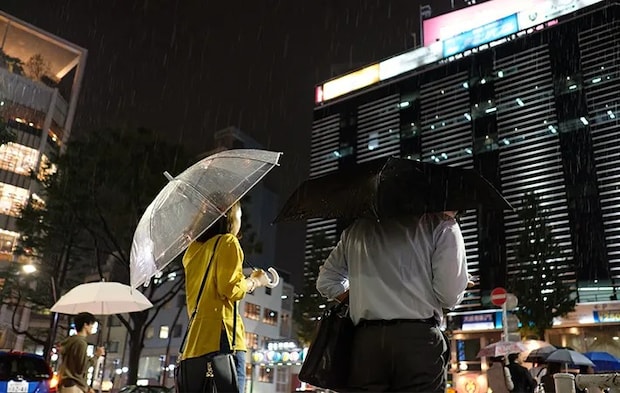 夜の街で傘をさす人の写真