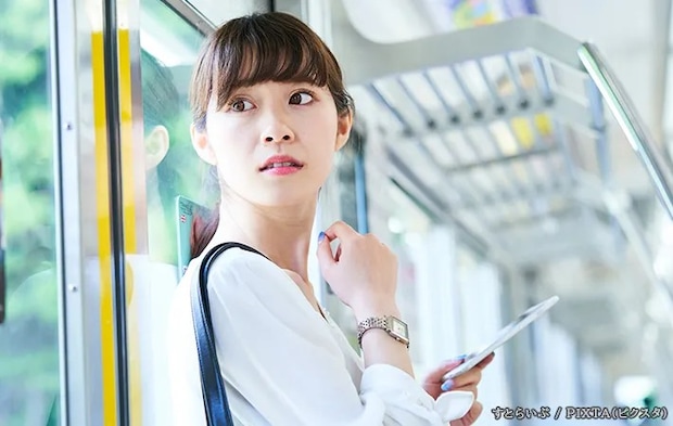 背後を気にする女性の写真