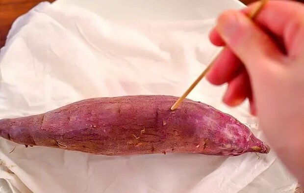 サツマイモに竹串を刺している写真（撮影：小泉明代）