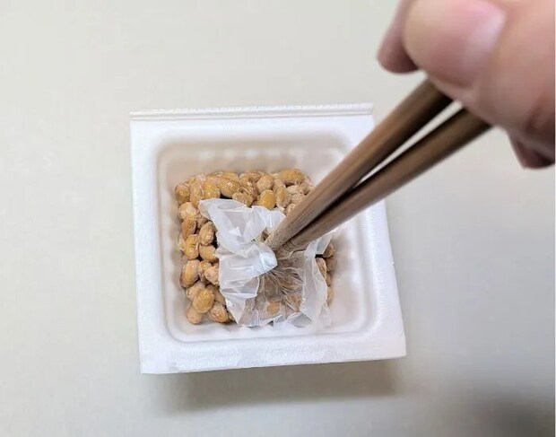 納豆の中でフィルムをかき混ぜている様子（撮影：grape編集部）