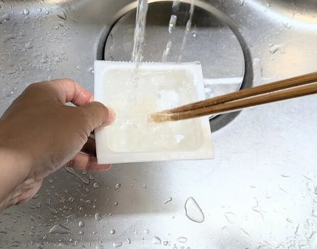 納豆のパックとフィルムを洗っている様子（撮影：grape編集部）