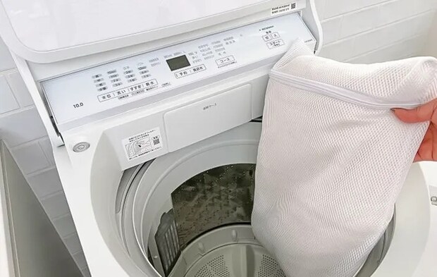 洗濯機に服を入れる写真（撮影：Heulie）