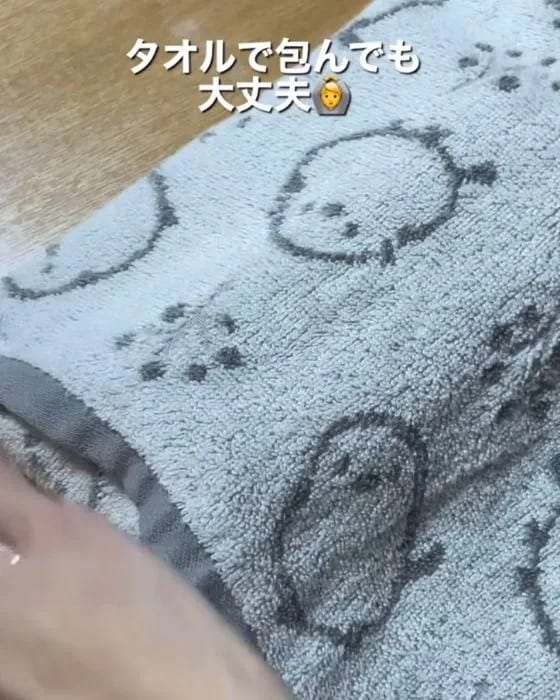 お寿司のパックをタオルで包んでいる様子