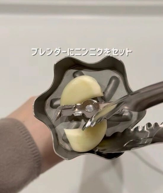 ハンドブレンダーにニンニクをセットする様子