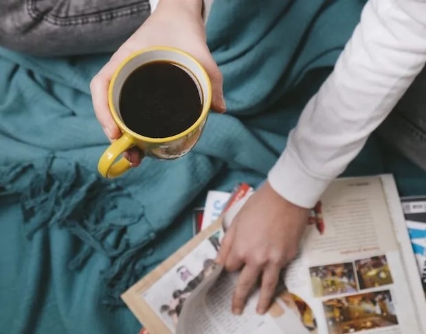 コーヒーを飲みながら雑誌を読んでいる様子