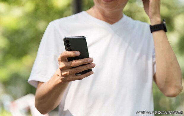 スマホを持つ男性の写真