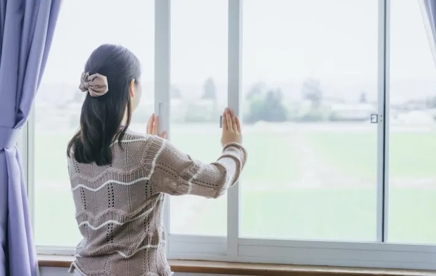 窓を開けている女性