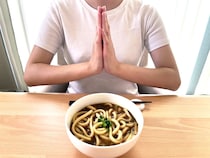 真っ白なTシャツなのに大丈夫？　カレーうどんを食べる女性が使った『カプセルトイの商品』とは【レビュー】