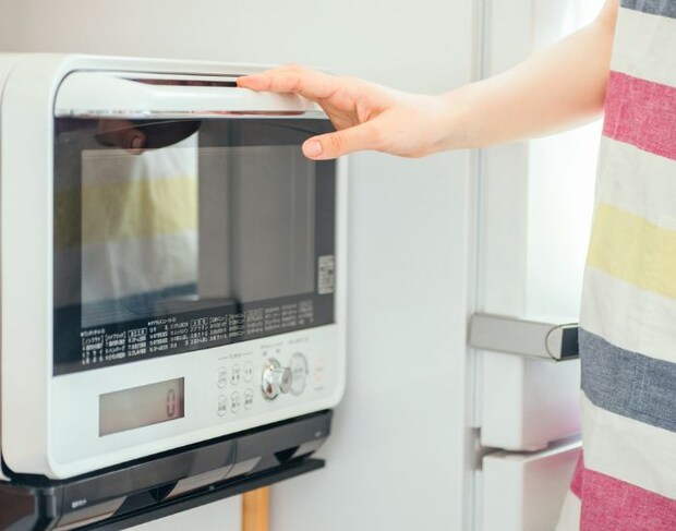 電子レンジの扉に手をかけている様子