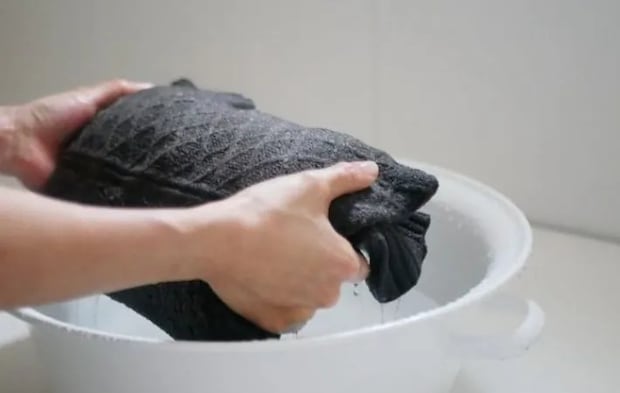 洋服を洗濯桶から取り出した様子