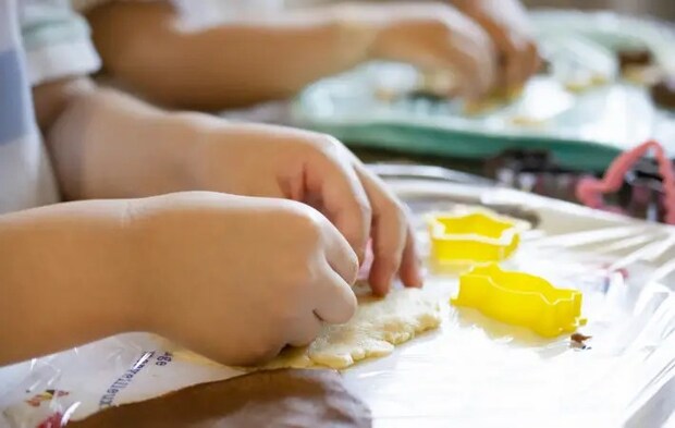 クッキーの型を抜いている子供