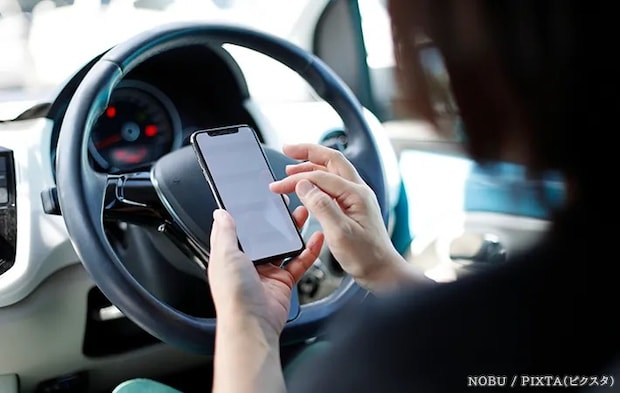 社内でスマホを操作する人の写真