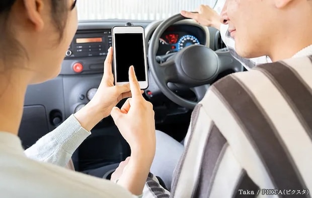 社内でスマホを見る人の写真