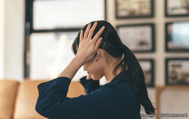 頭に手を置く女性の写真