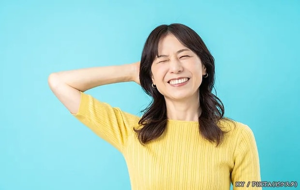 手を頭にあてる女性の写真