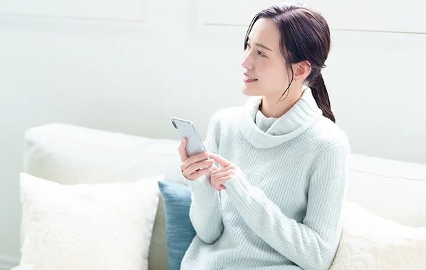 スマホを持つ女性の写真