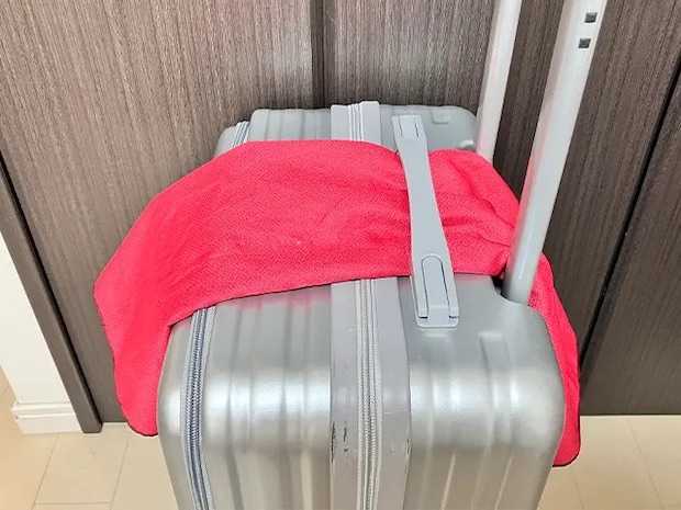 風呂敷をキャリーケースの持ち手に通す（撮影：grapeライフハック編集部）