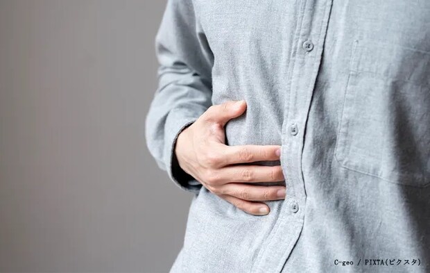 お腹をおさえる男性の写真