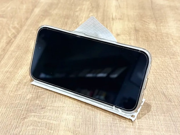 紙で作ったスマホスタンドに『iPhone 16』を立てた画像（撮影：grapeライフハック編集部）