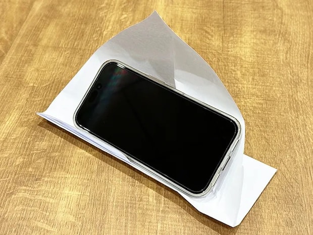 紙で作ったスマホスタンドに『iPhone 16』を立てた画像（撮影：grapeライフハック編集部）