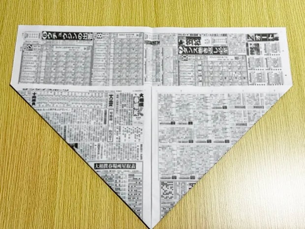 新聞紙の左右の下の角を真ん中の選に向かって三角に折った画像（撮影：grapeライフハック編集部）