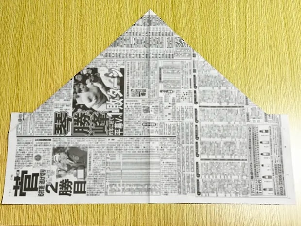 新聞紙を裏返して側面を中心に向かって折った画像（撮影：grapeライフハック編集部）