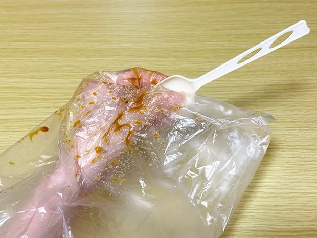 『アイラップ』の中に手を入れ、袋越しにスプーンを握っている画像（撮影：grapeライフハック編集部）
