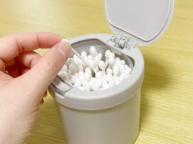 『ワンタッチ綿棒ケース』に綿棒を入れている画像（撮影：grapeライフハック編集部）