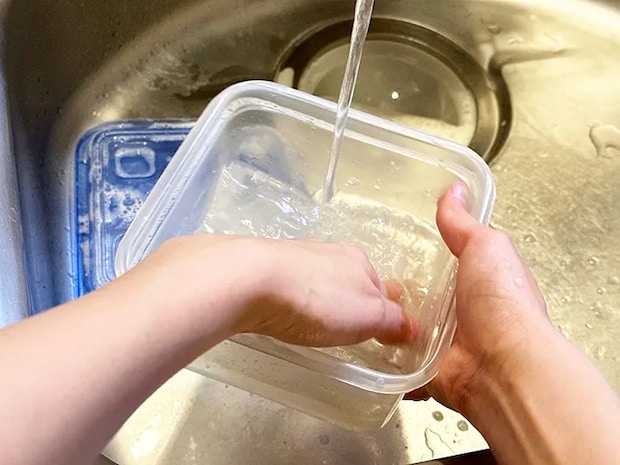 プラ容器の蓋を開け、水洗いをしている画像（撮影：grapeライフハック編集部）