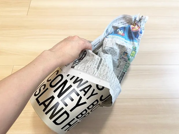 新聞紙の上の部分をねじっている画像（撮影：grapeライフハック編集部）