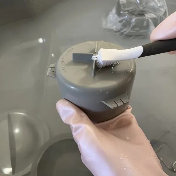 排水口のパーツをブラシで洗っている様子（撮影：grapeライフハック編集部）