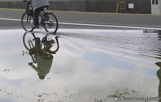 『水たまり』の横を通る自転車の写真