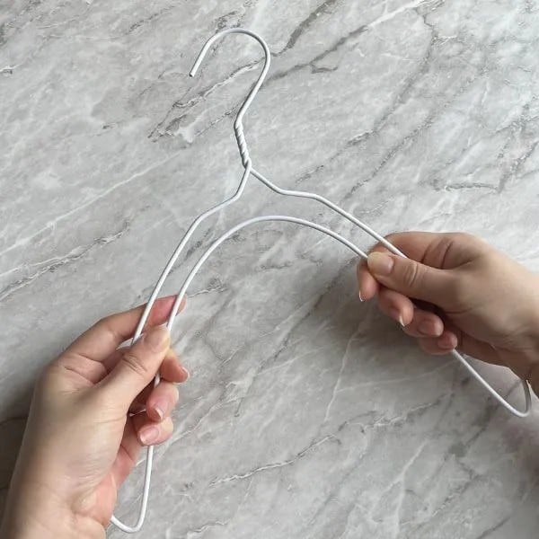 針金ハンガーの両端を下に曲げる様子（撮影：grapeライフハック編集部）