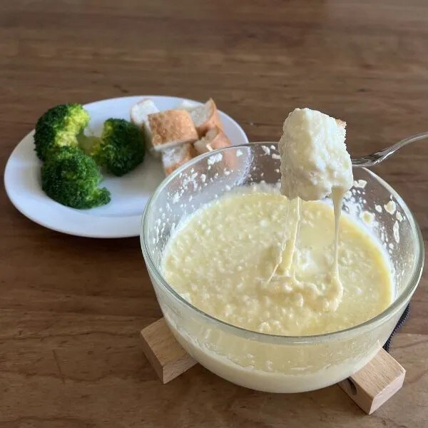 バゲットやブロッコリーに豆腐のチーズフォンデュを絡めて食べている様子（撮影：grapeフード編集部）