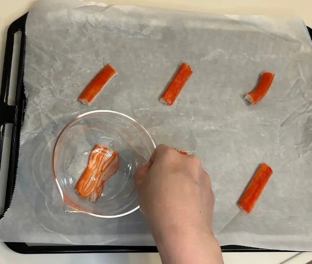 カニカマを押さえて広げている様子（撮影：grapeフード編集部）