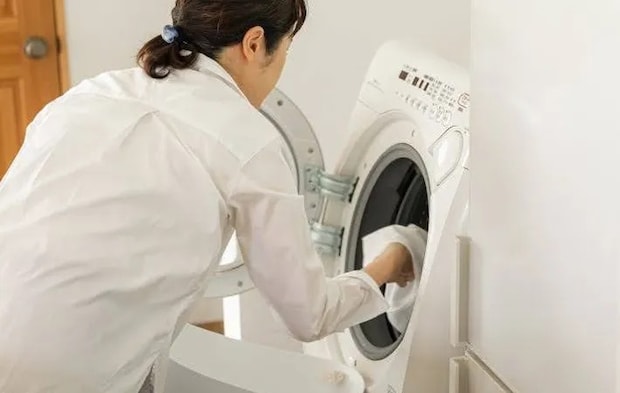 『洗濯物を洗濯槽に入れる女性』の写真（撮影：Heulie）