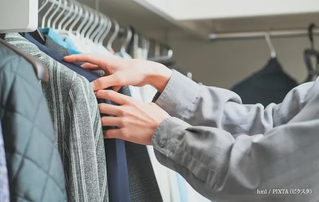 『衣類の整理をする男性』の写真
