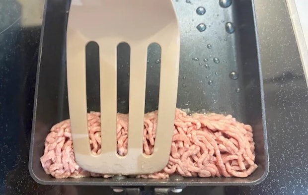 フライ返しで肉の形を整えている画像（撮影：エニママ）