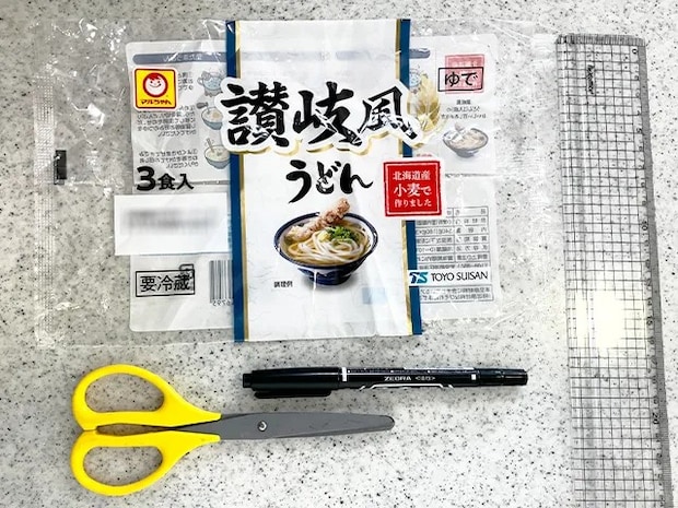 うどんの袋、ペン、ハサミ、定規をキッチンに置いた場面（撮影：grapeライフハック編集部）