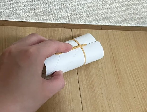 トイレットペーパーにつけた輪ゴムで床を掃除する写真（撮影：grapeライフハック編集部）