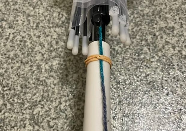 毛糸を傘の持ち手に輪ゴムで固定する写真（撮影：grapeライフハック編集部）